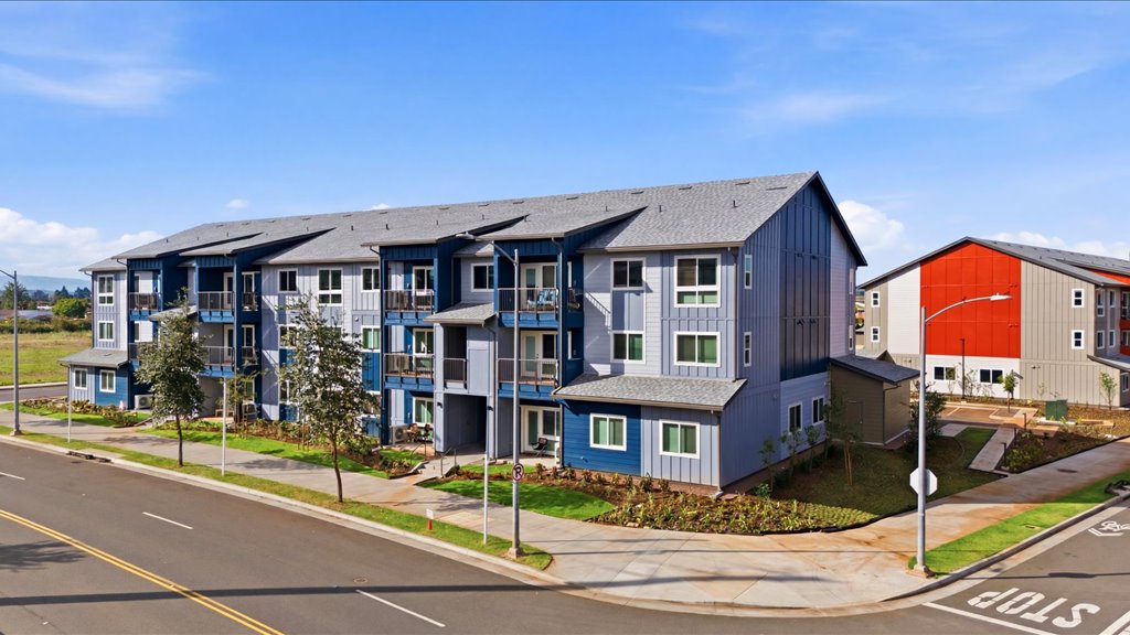 Exterior three story building with blue and gray wood cladding