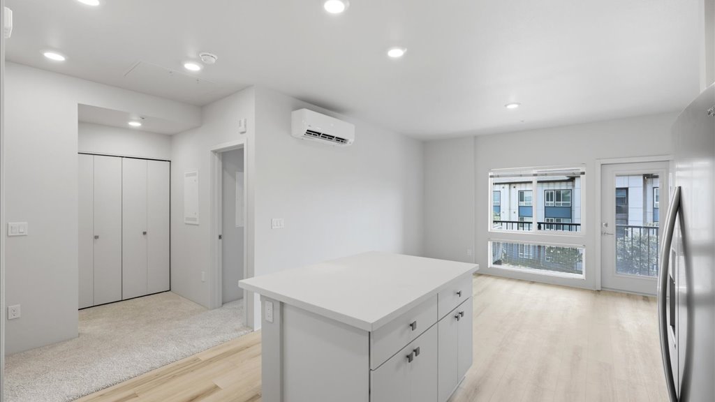 Interior kitchen with stainless steel appliances open to living room and lanai