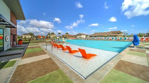Community amenity community pool with orange pool chairs