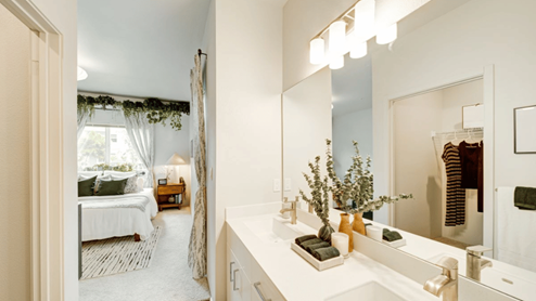 Interior bathroom with two sinks open to the bedroom