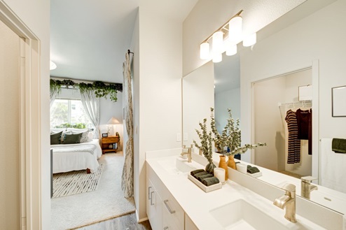 Interior bathroom with two sinks open to bedroom