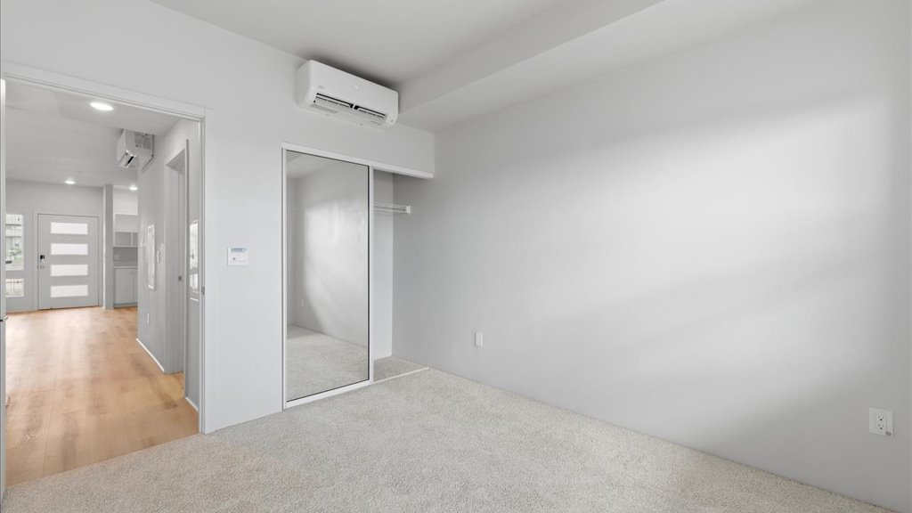 Interior bedroom with sliding door closet and door to exterior yard