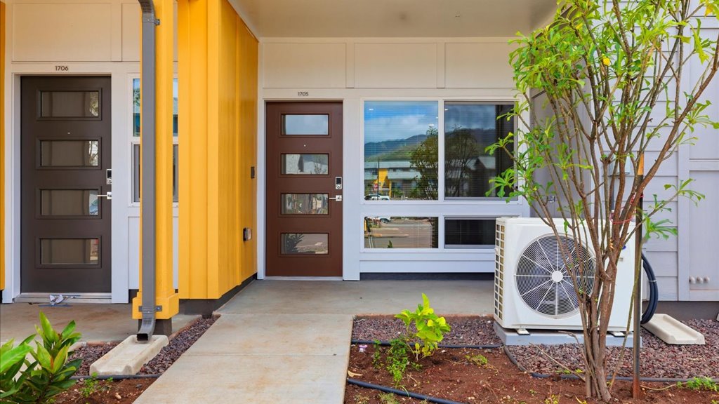 Exterior three story building with yellow and blue wood cladding