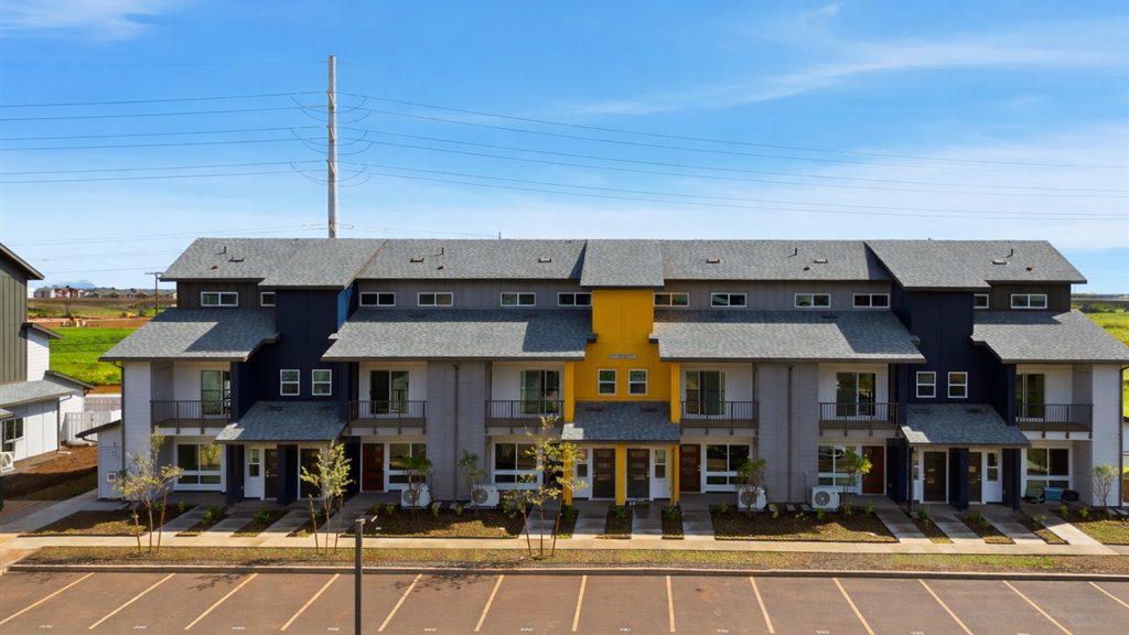 Exterior three story building with yellow and blue wood cladding