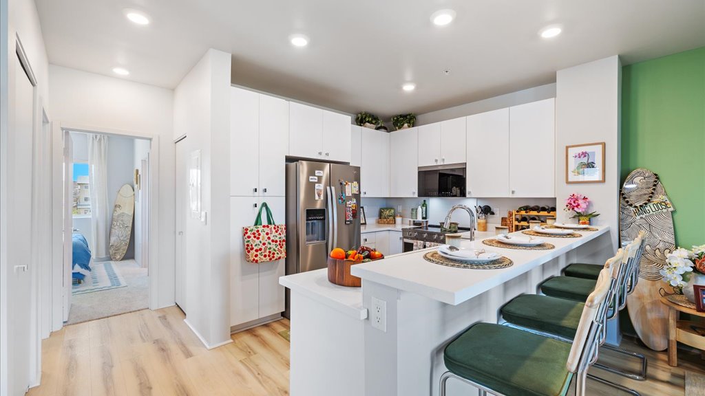 Interior kitchen with stainless steel appliances open to living room