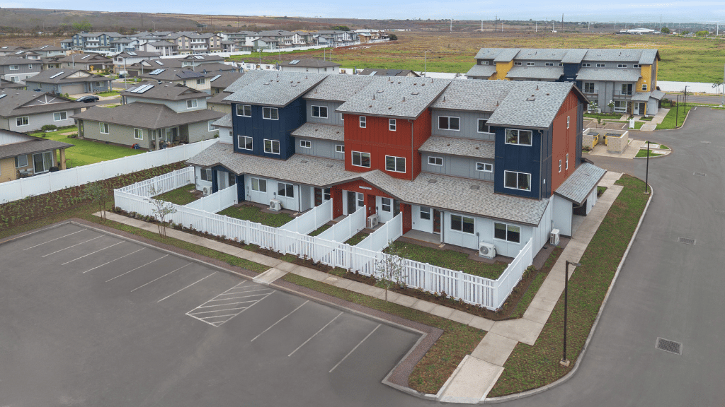 Exterior three story building with red and blue wood cladding