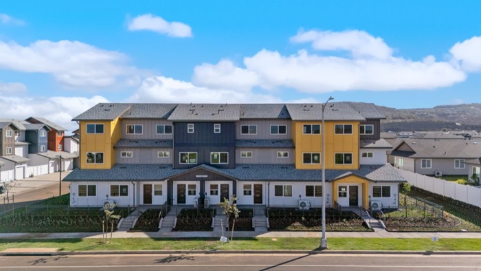Exterior three story yellow, blue, and grey building