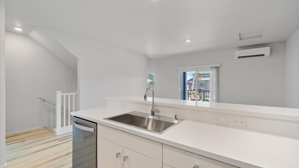 Interior kitchen with stainless steel appliances open to living room