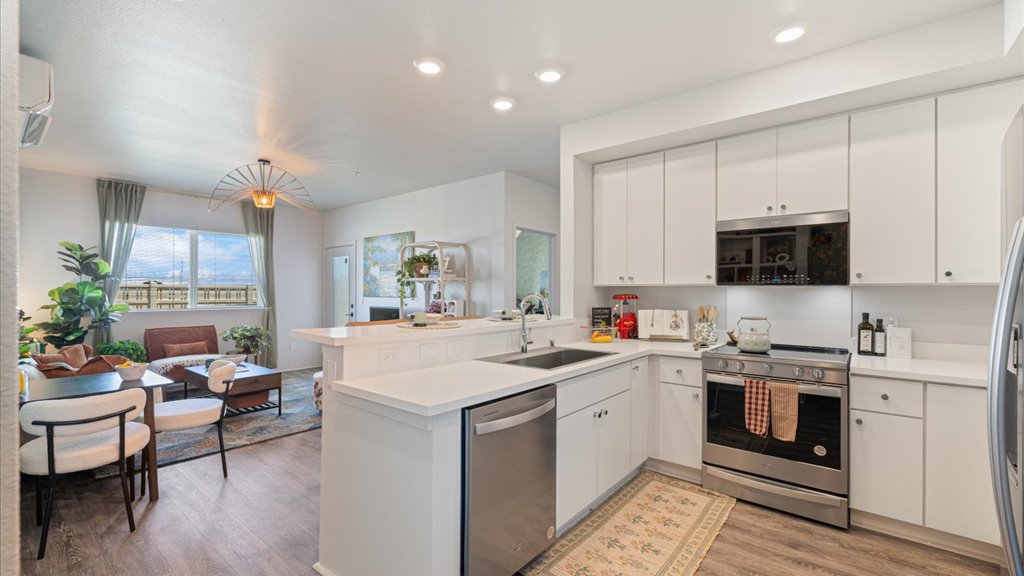 Interior kitchen with stainless steel appliances open to living room