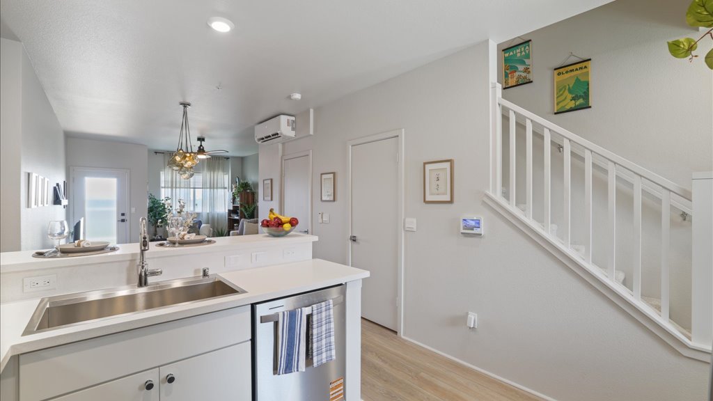 Interior kitchen with stainless steel appliances open to stairs