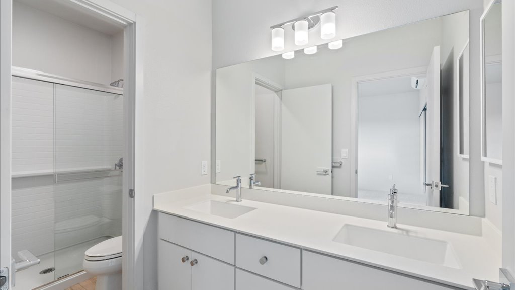 Interior bathroom with walk in shower and vanities