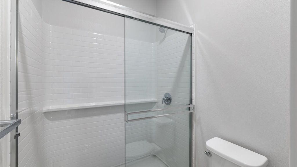 Interior bathroom with walk in shower and vanities