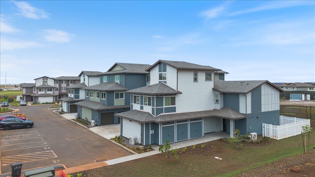 Exterior three story building with blue wood cladding and motorcross garages