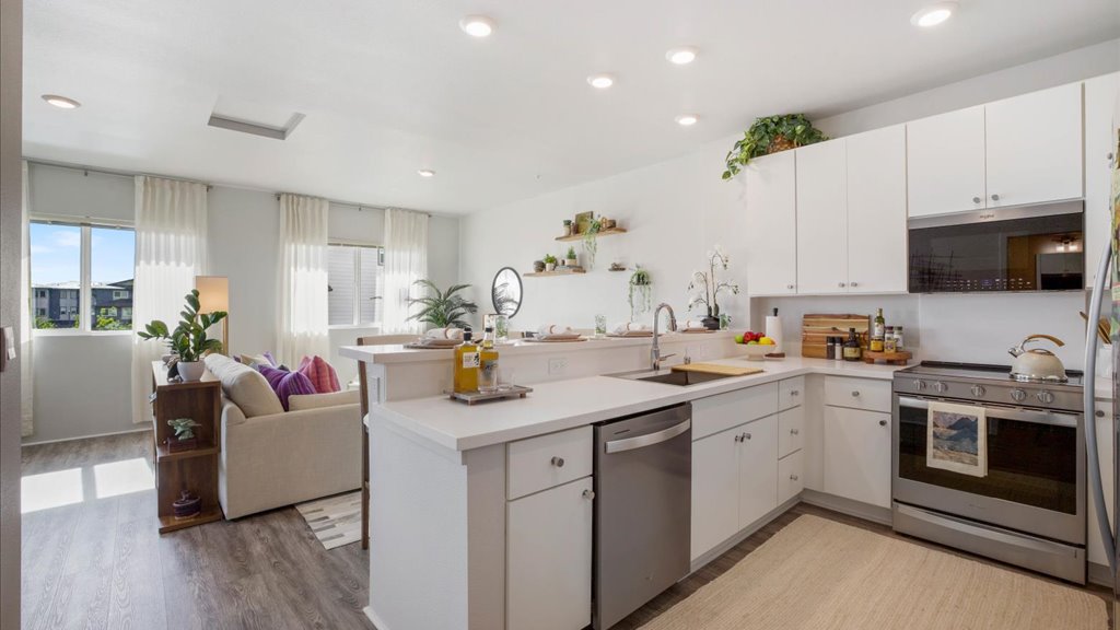 Interior kitchen with stainless steel appliances open to living room