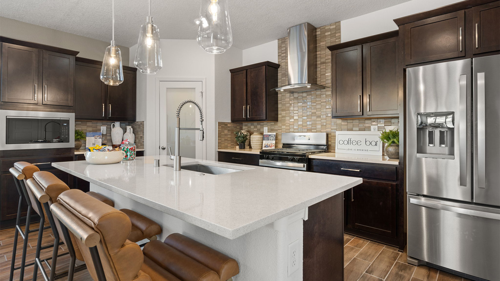 Central kitchen island anchors the home adding a dining option, full sink, pantry and storage, multi-prep zones