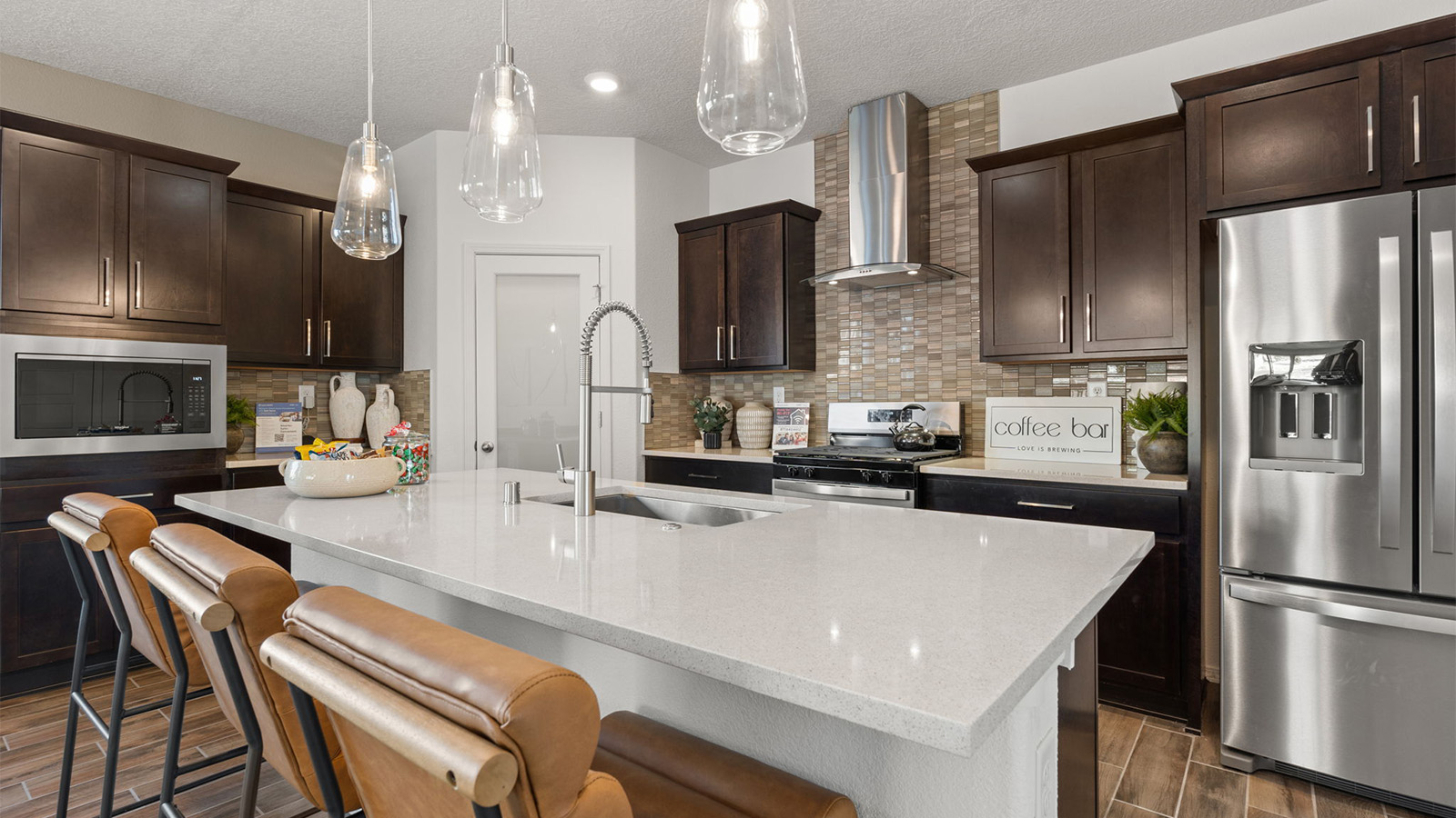 Central kitchen island adds a sink, seating, designed to anchor the home, pantry, prep zones, perfect for entertaining, everyday life