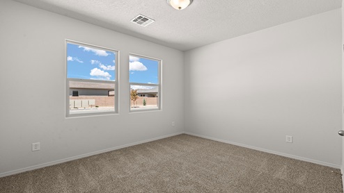 first secondary bedroom with two windows and carpet floors with closet