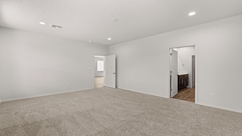 Primary suite with carpet floors and two windows