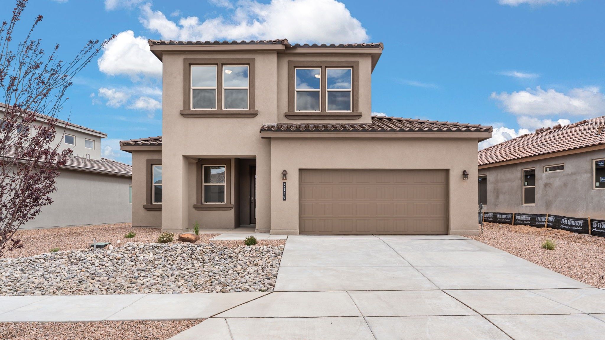 Bliss front exterior two-story home with concrete drive way, brown home with dark brown accents, tile roof, and front yard landscaping