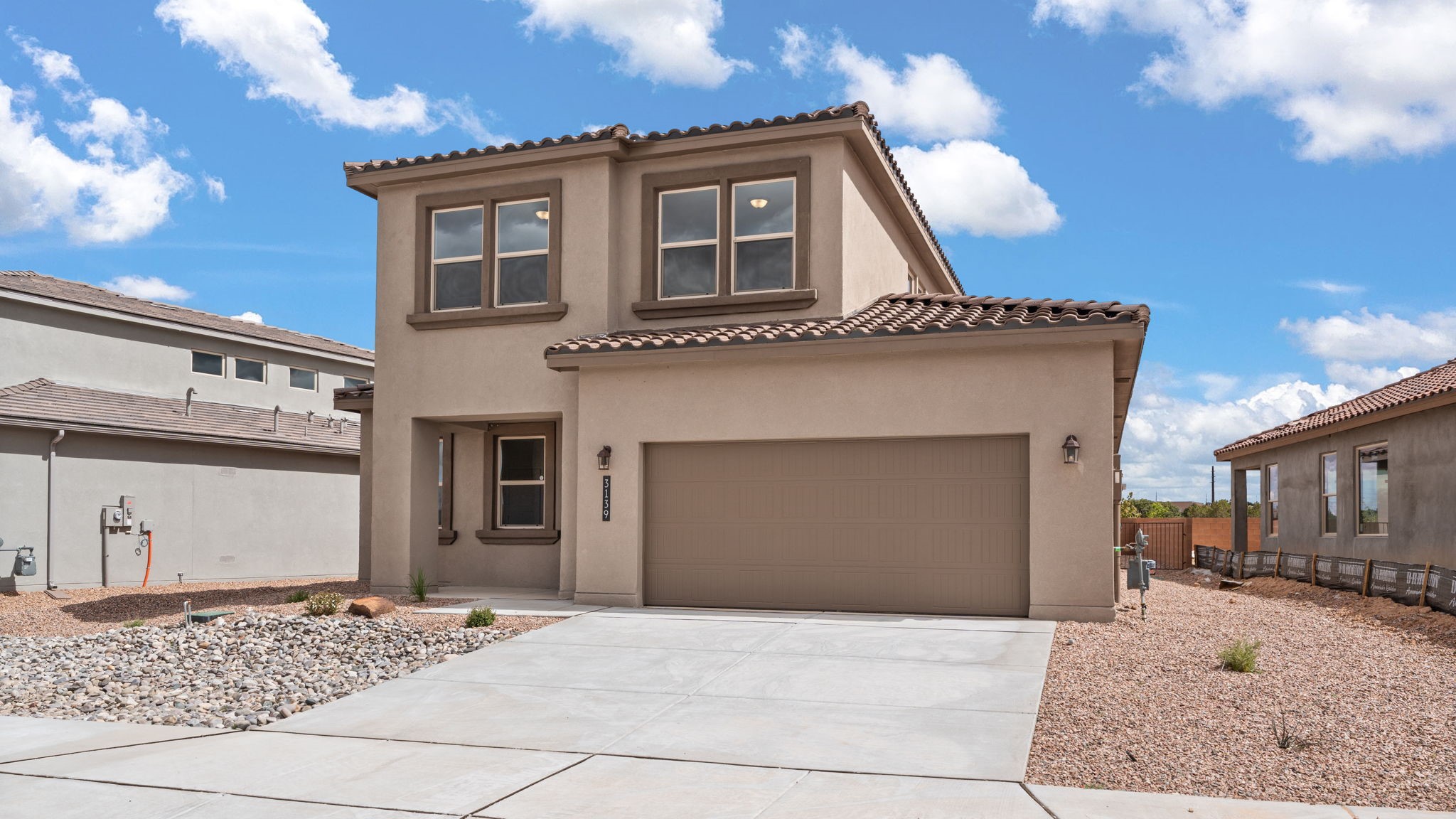 Bliss front exterior two-story home with concrete drive way, brown home with dark brown accents, tile roof, and front yard landscaping