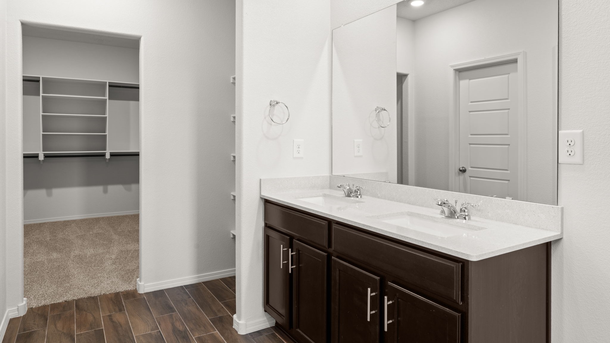 Primary bathroom with dual sinks, standing shower with tile surrounds, and tile floor