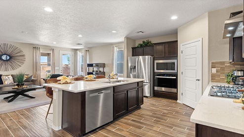 kirchen with brown cabinets, island, stainless steel appliances, and granite countertops