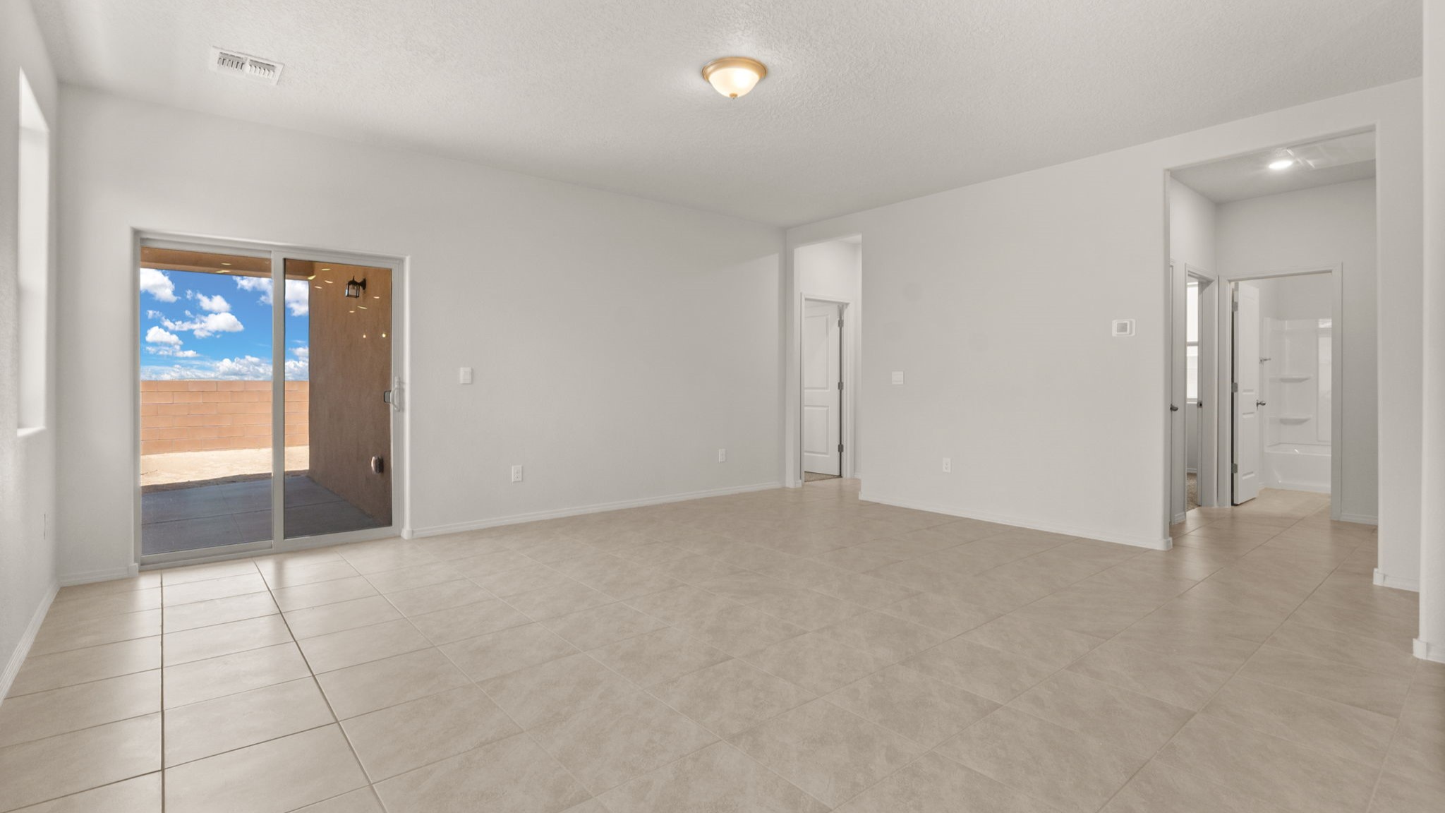Kitchen view towards living and outdoor spaces showing open confort and backyard access at Vista Grande