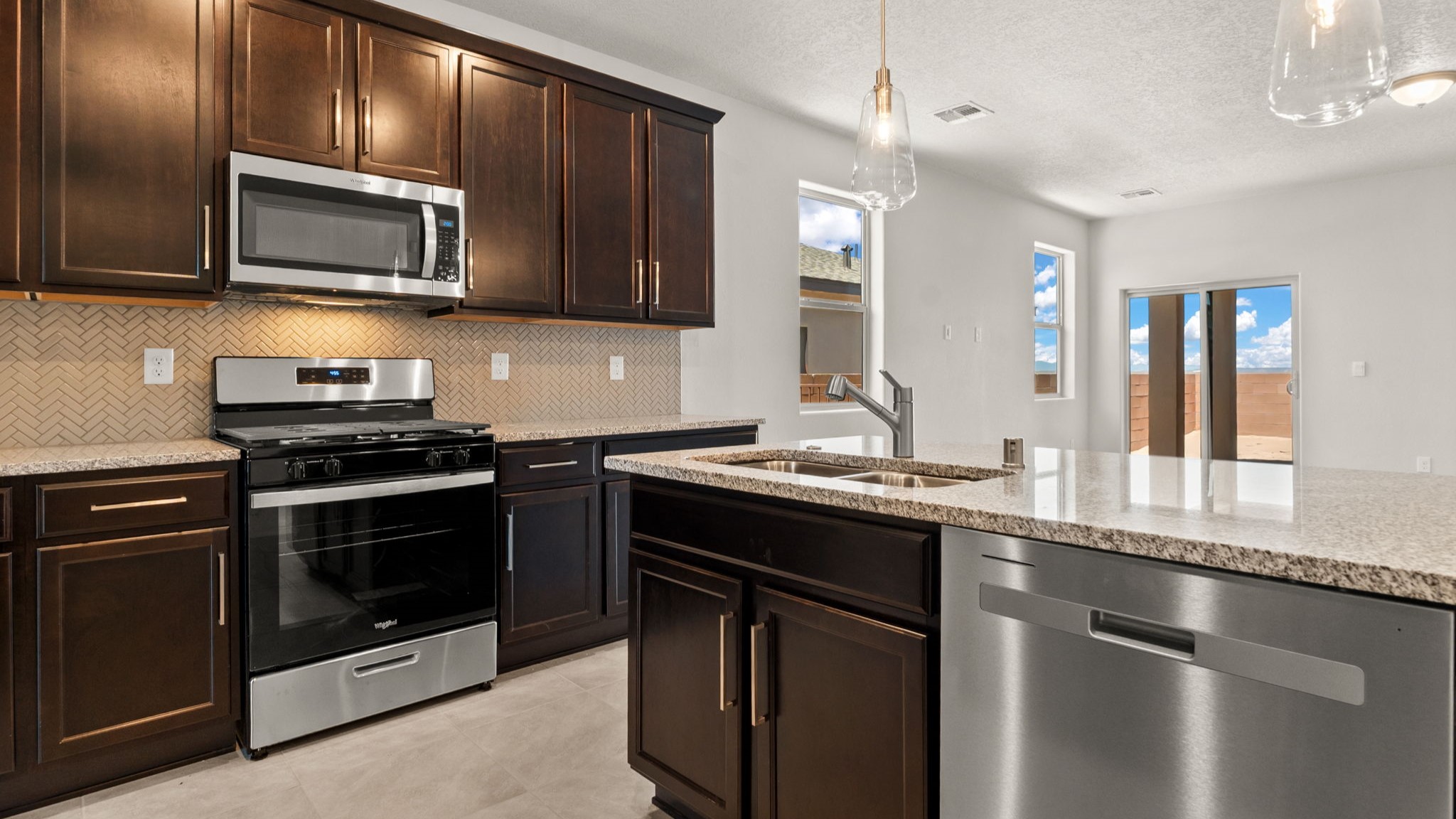 Kitchen with appliance suite included, with pantry and ample cabinet storage and clean modern design choices at Vista Grande