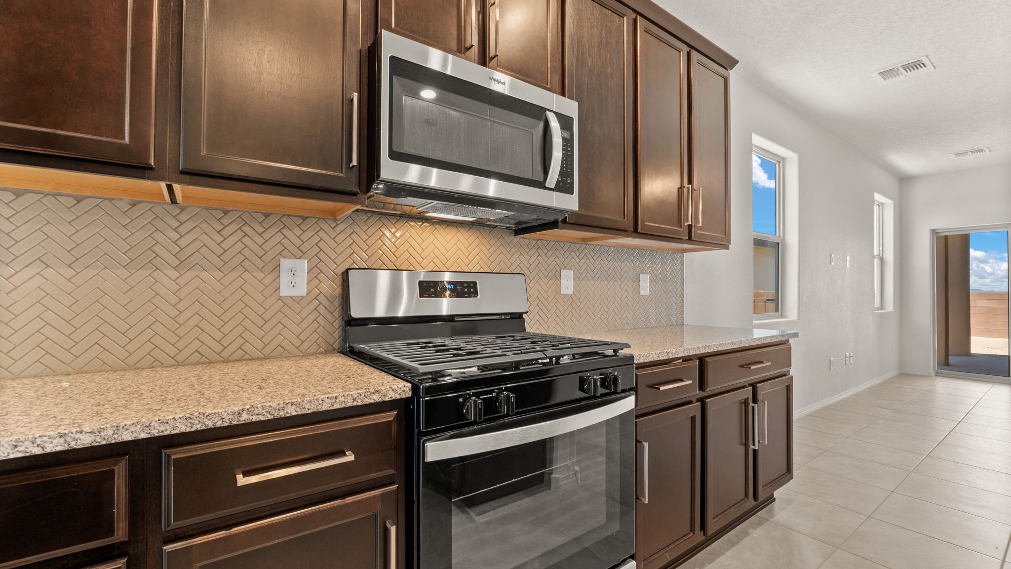 Kitchen with appliance suite included, with pantry and ample cabinet storage and clean modern design choices at Vista Grande