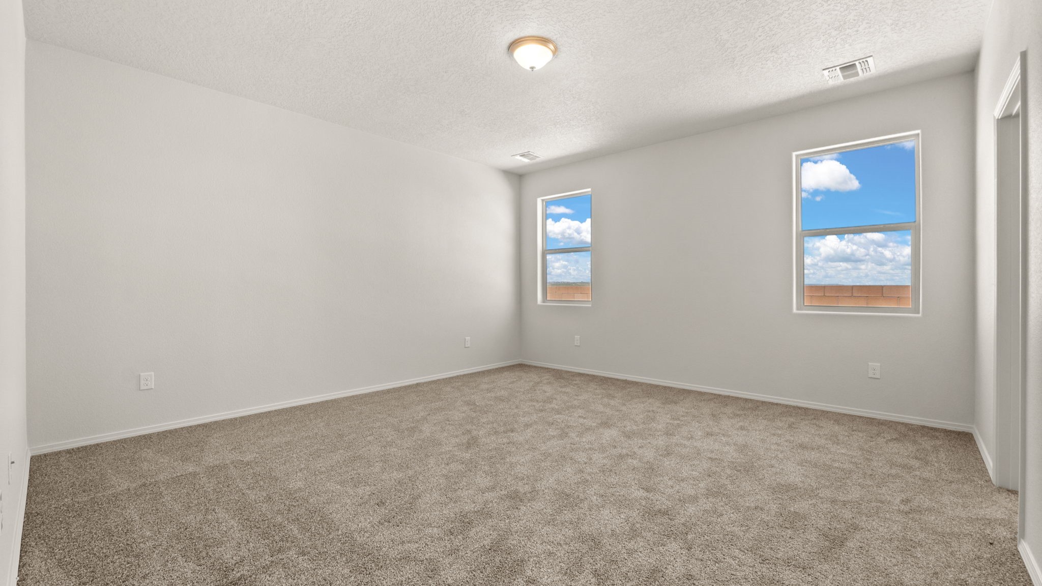 Primary bedroom with open wall space for adding décor and ensuite and walk-in closet at Vista Grande