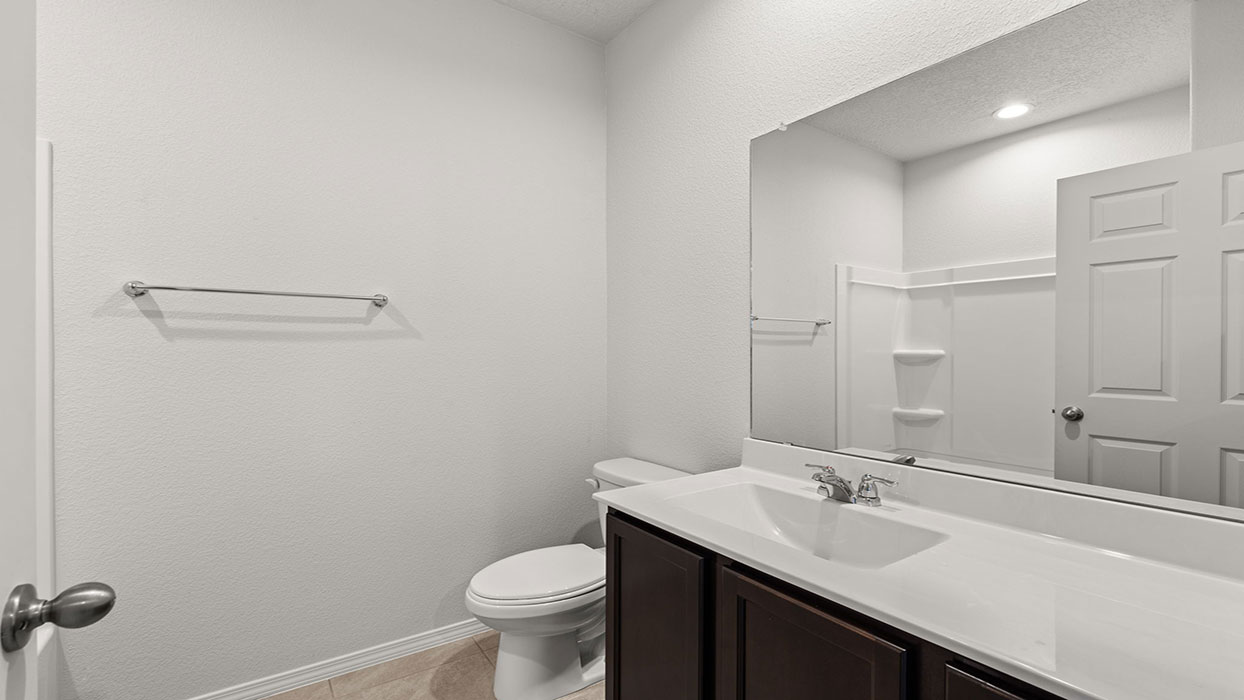 Secondary hallway bathroom with tub/shower combo and vanity with lower cabinets and tile floor