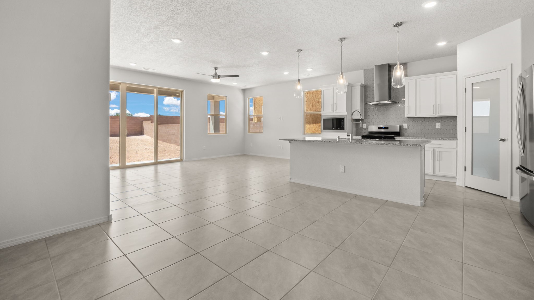 Dining area with white walls, brown tile, and natural lighting.