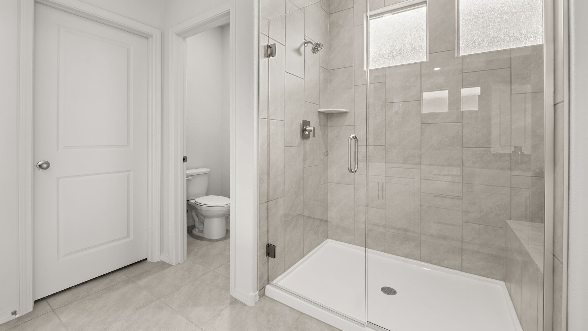 Bathroom with a walk in shower, a door for toilet, and a walk in closet.