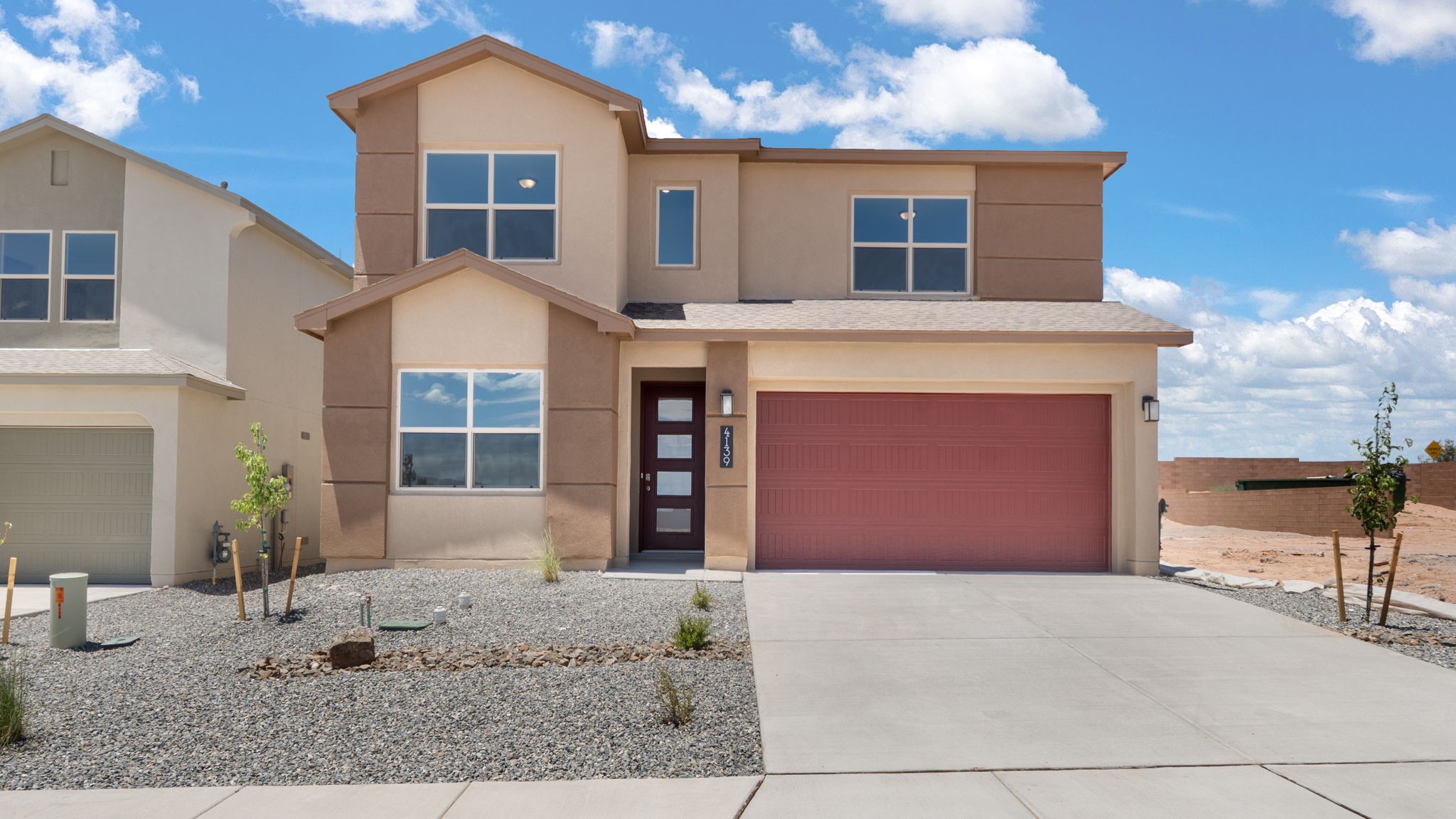 Two story home with a brown exterior and a two car garage.