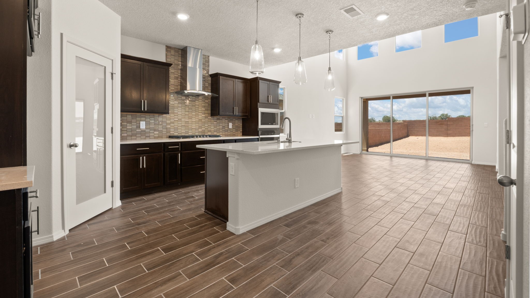 Kitchen with brown cabinets, stainless steel appliances, and white countertops.