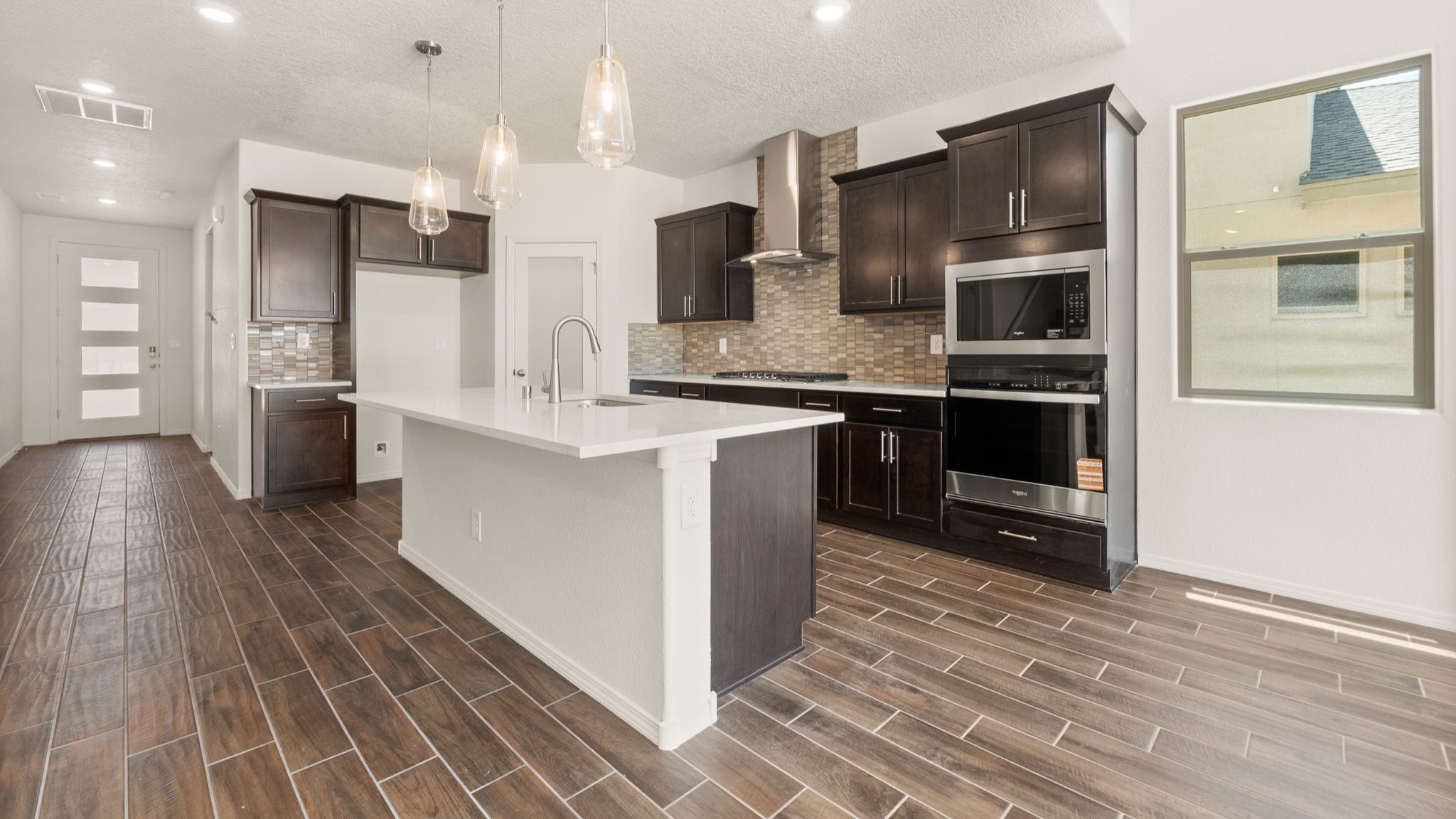 Kitchen with brown cabinets, stainless steel appliances, and white countertops.
