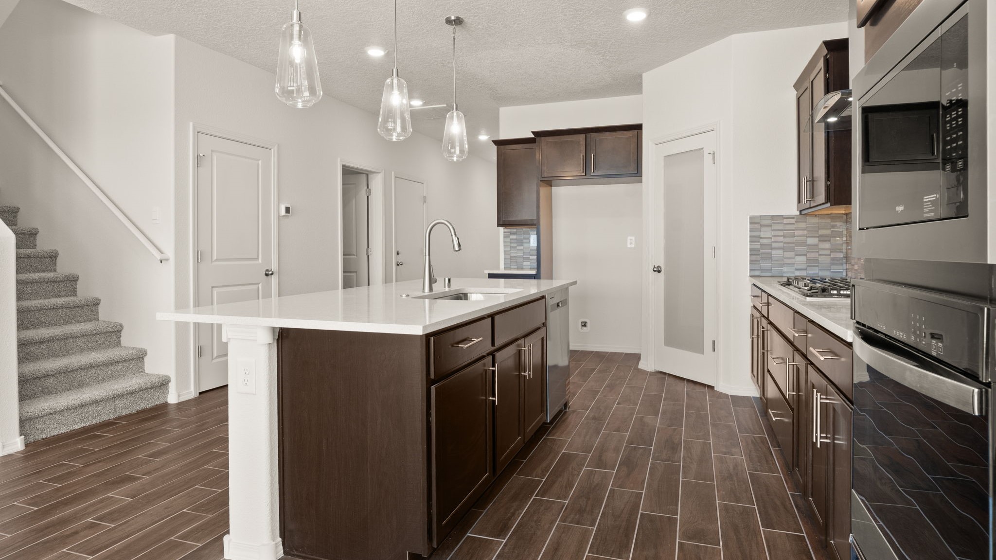 Kitchen with brown cabinets, stainless steel appliances, and white countertops.