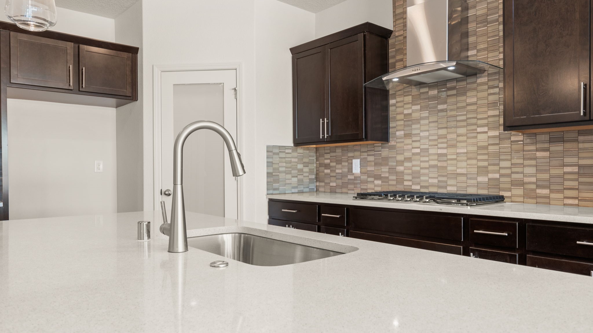 Kitchen with brown cabinets, stainless steel appliances, and white countertops.