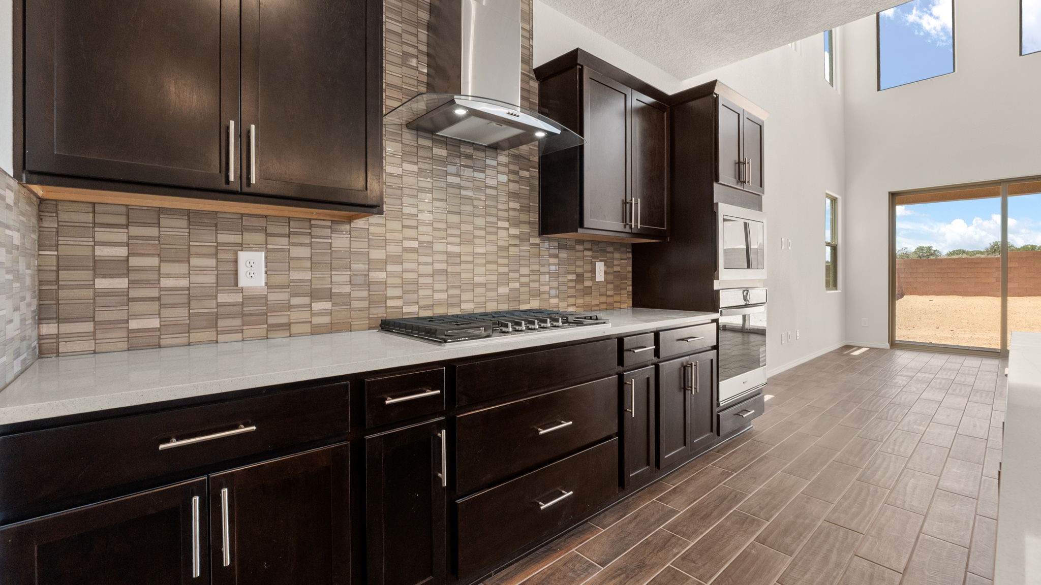Kitchen with brown cabinets, stainless steel appliances, and white countertops.