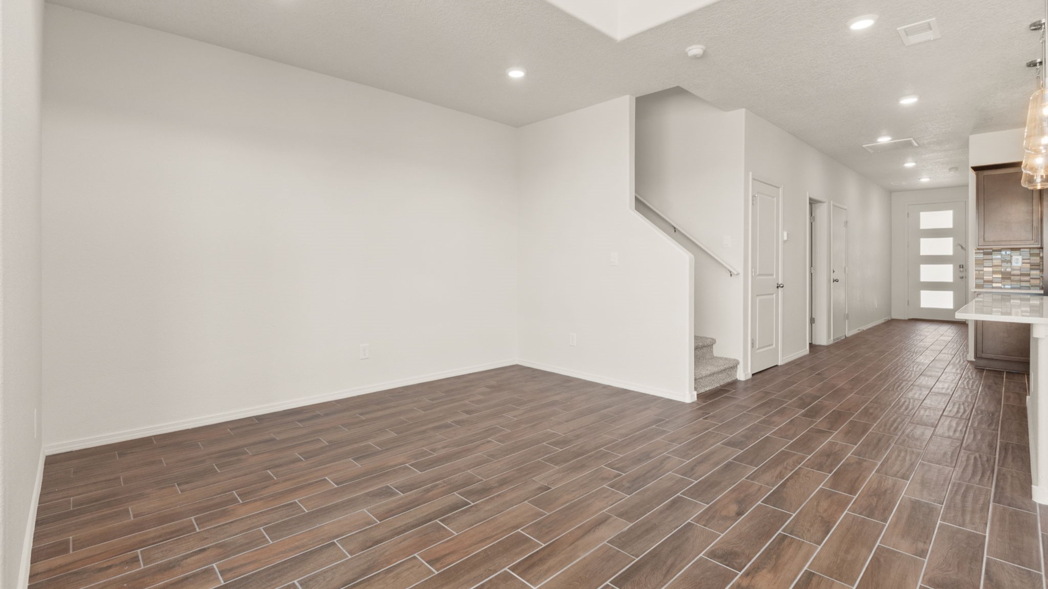 Dining area with brown wood floors and white walls.