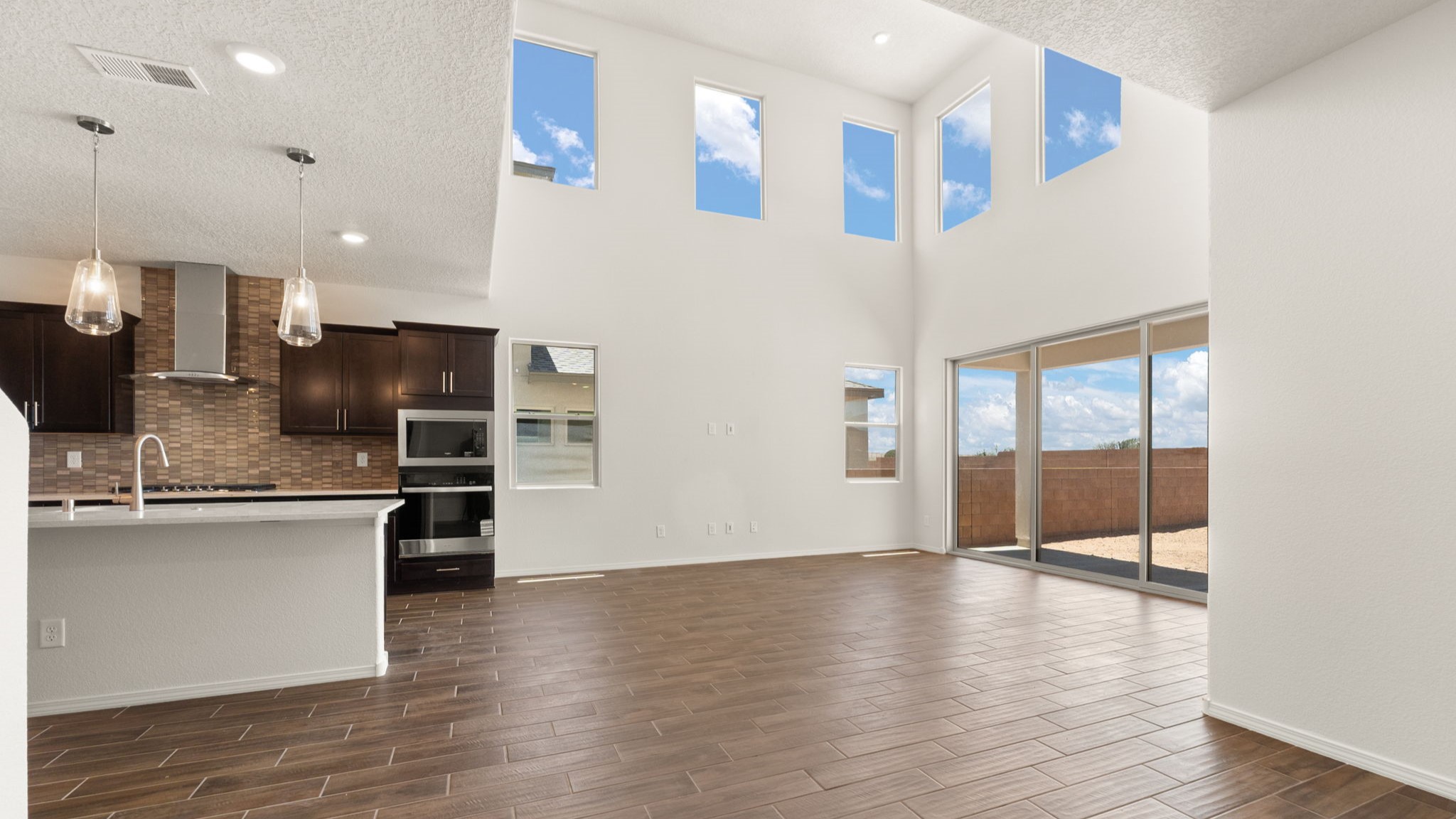 Living area with brown wood flooring, white walls, and a sliding door.