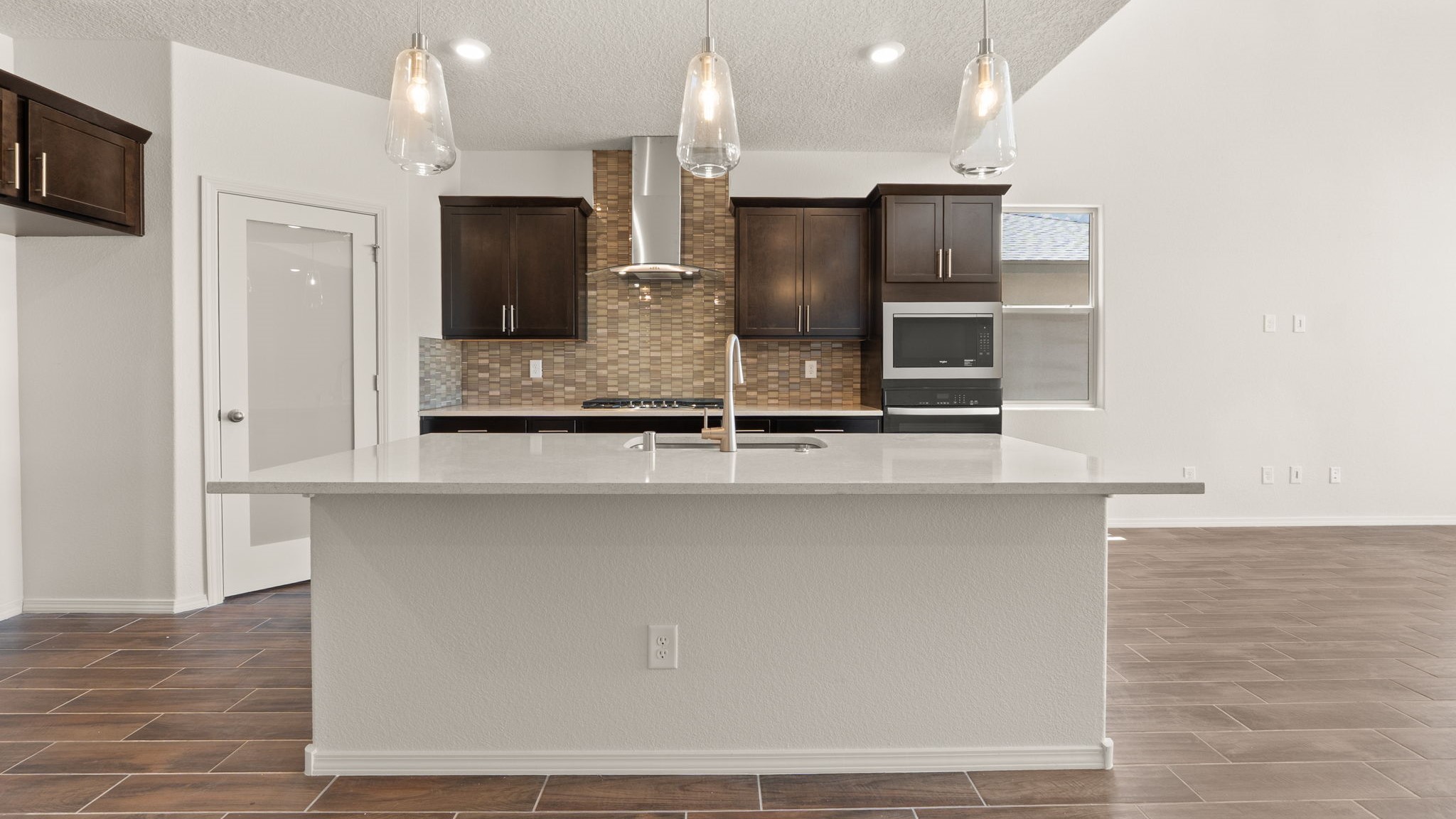 Kitchen with brown cabinets, stainless steel appliances, and white countertops.