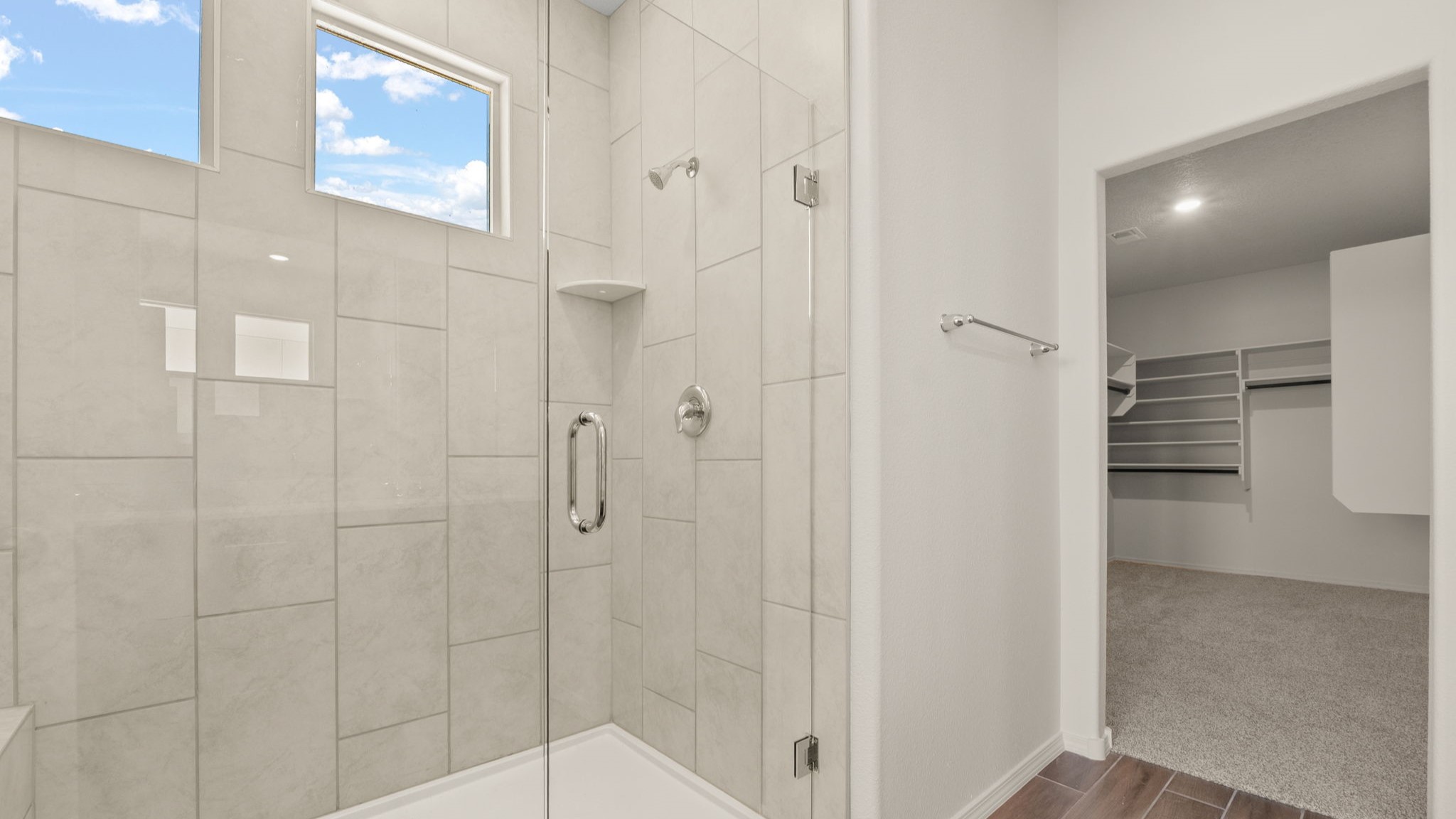 Bathroom with a walk in shower and a walk in closet.