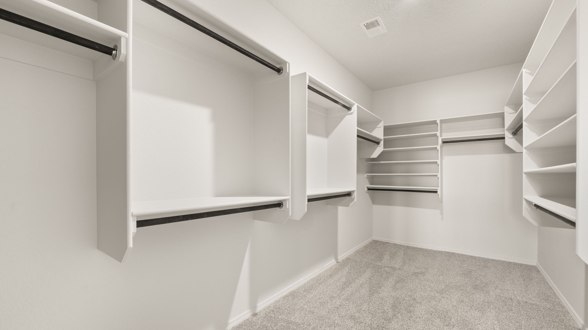 Spacious walk in closet with built in shelving.