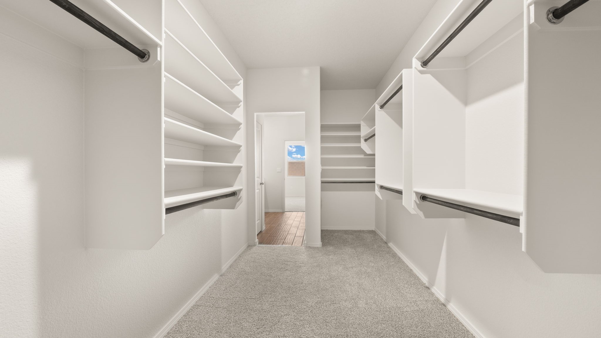 Spacious walk in closet with built in shelving.