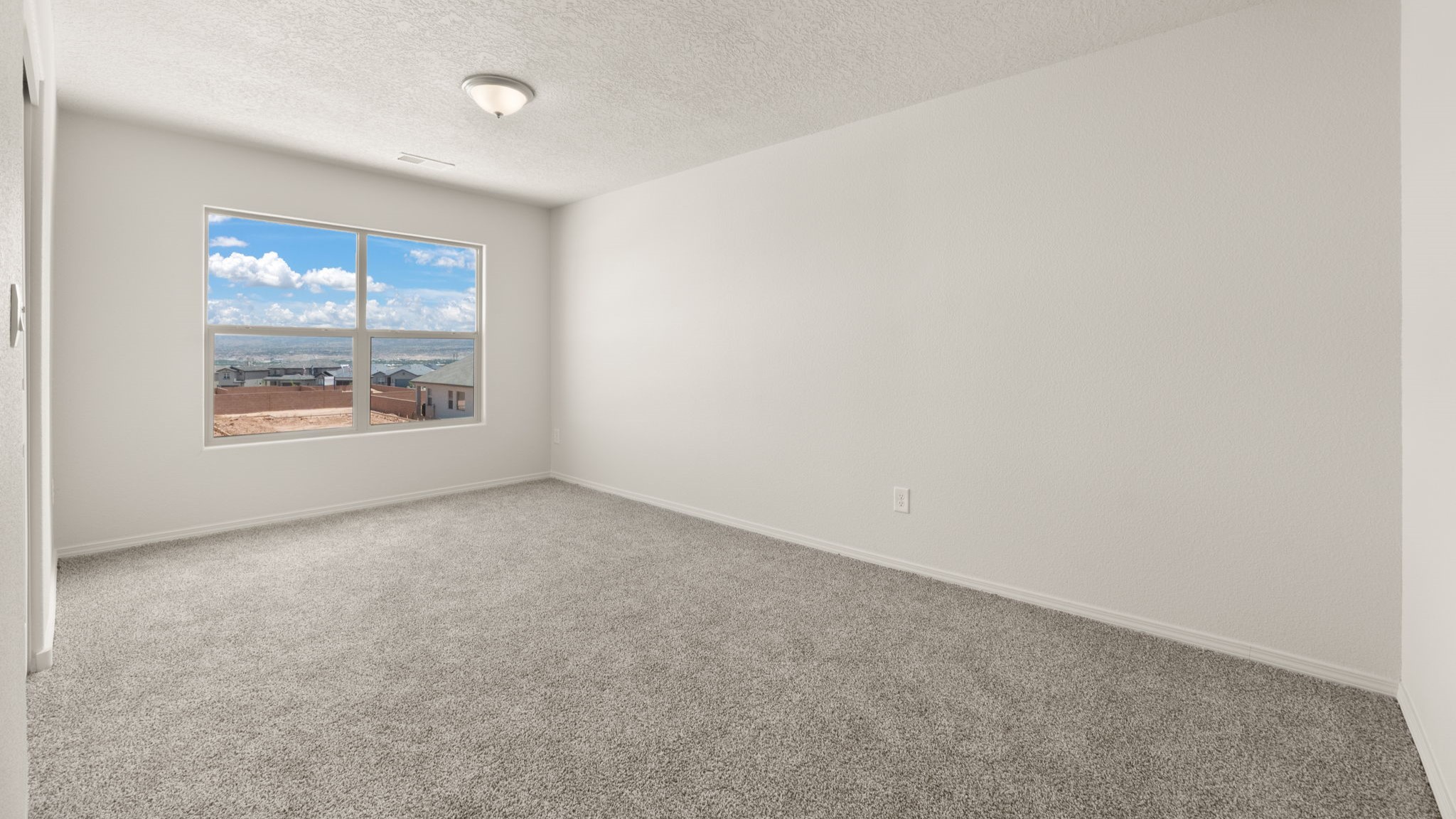 Bedroom with brown carpet, white walls, and a window.