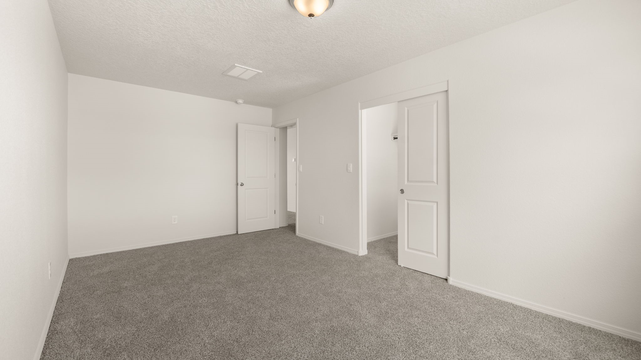 Bedroom with brown carpet, white walls, and a closet.