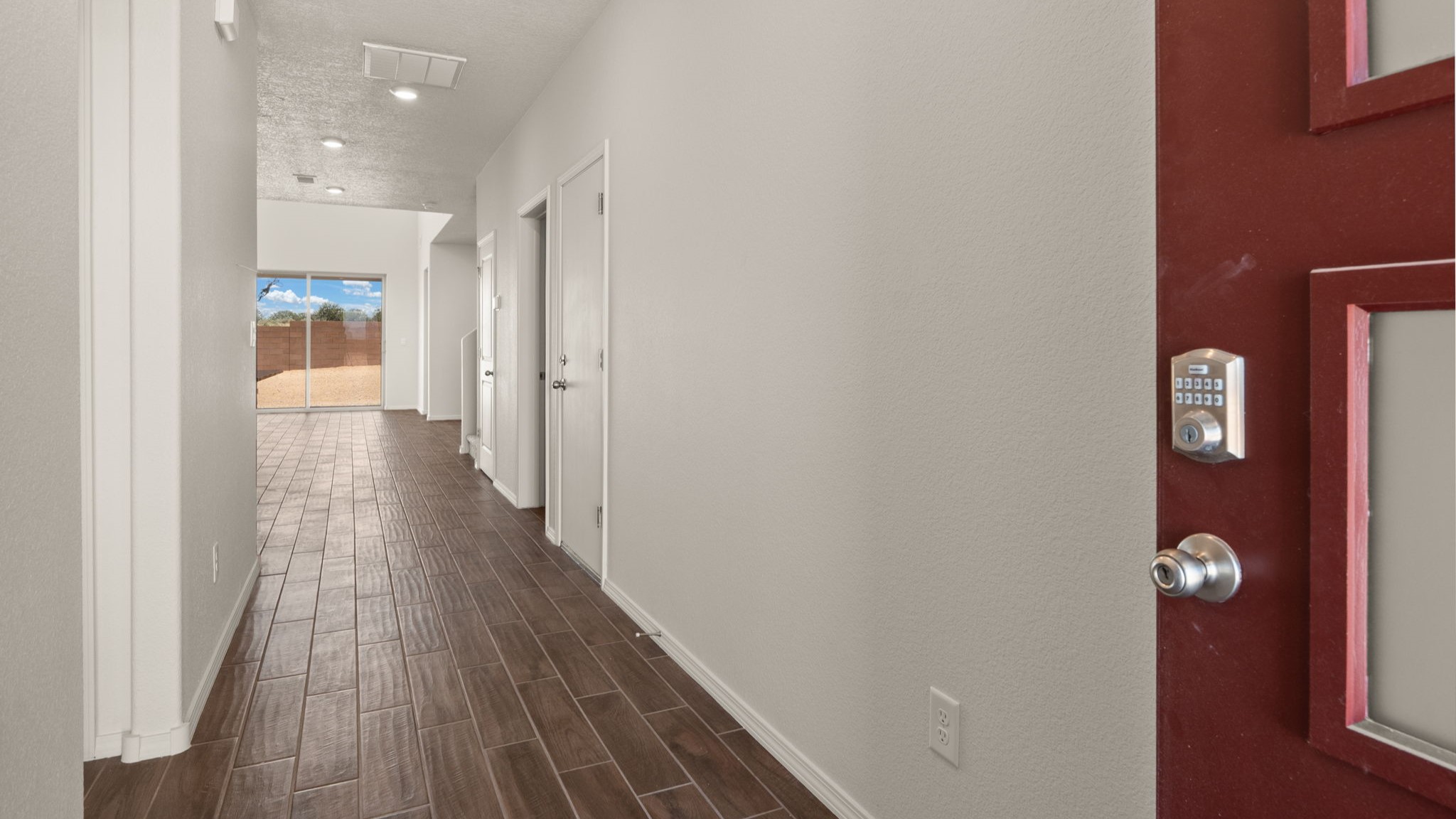 Entryway with brown wood flooring and white walls.