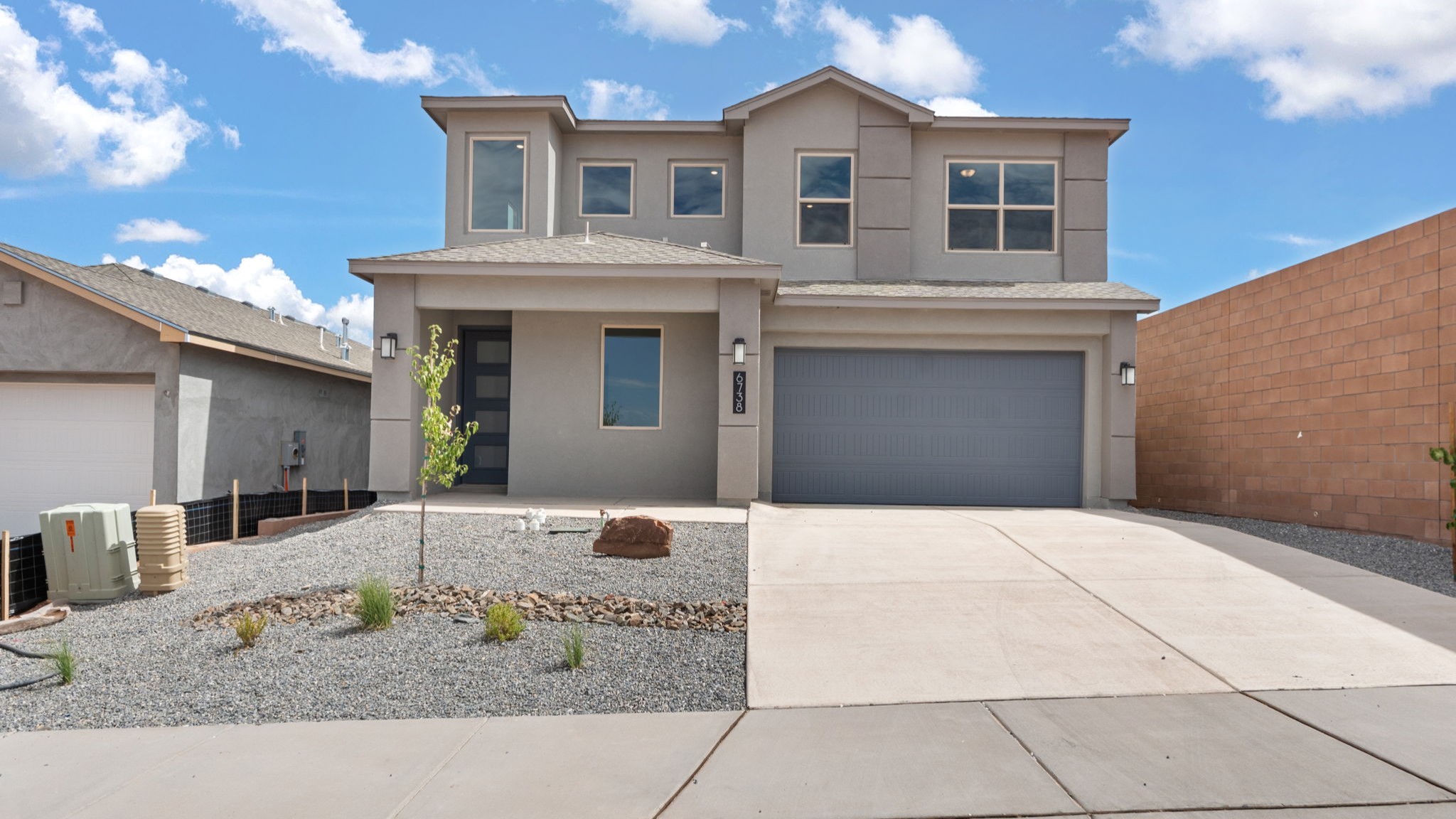 Two story home with a brown exterior and a two car garage.