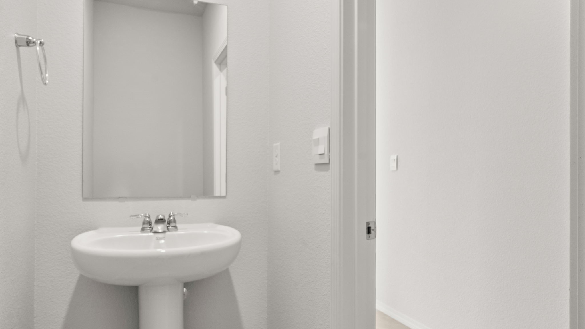 Half bath with a sink and white walls.